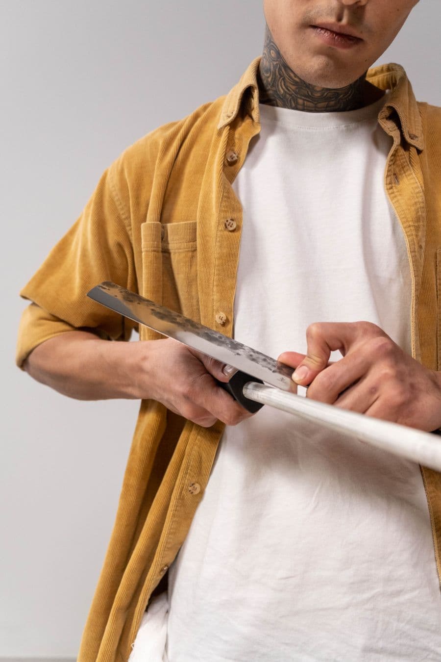 Hand honing a chef knife against a sharpening rod