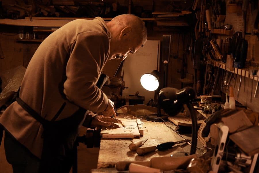 Craftsman working at a workbench in a warmly lit workshop