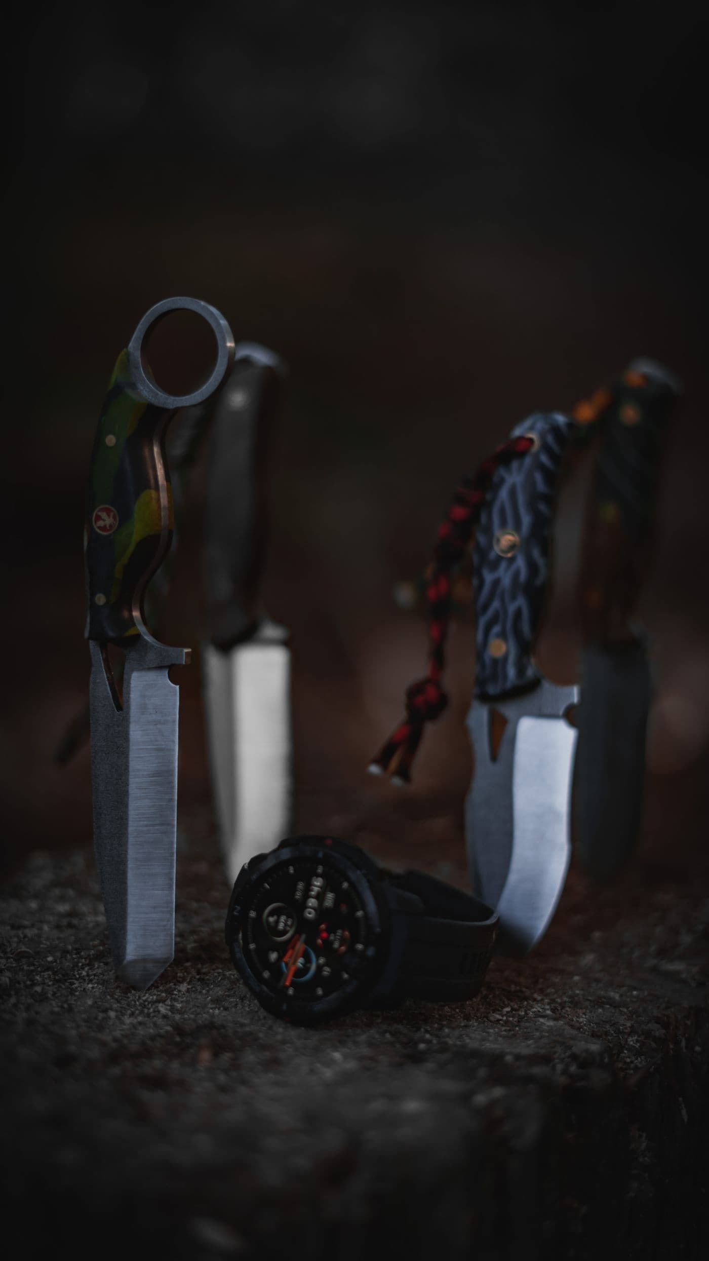 Collection of hunting knives on a dark stone surface