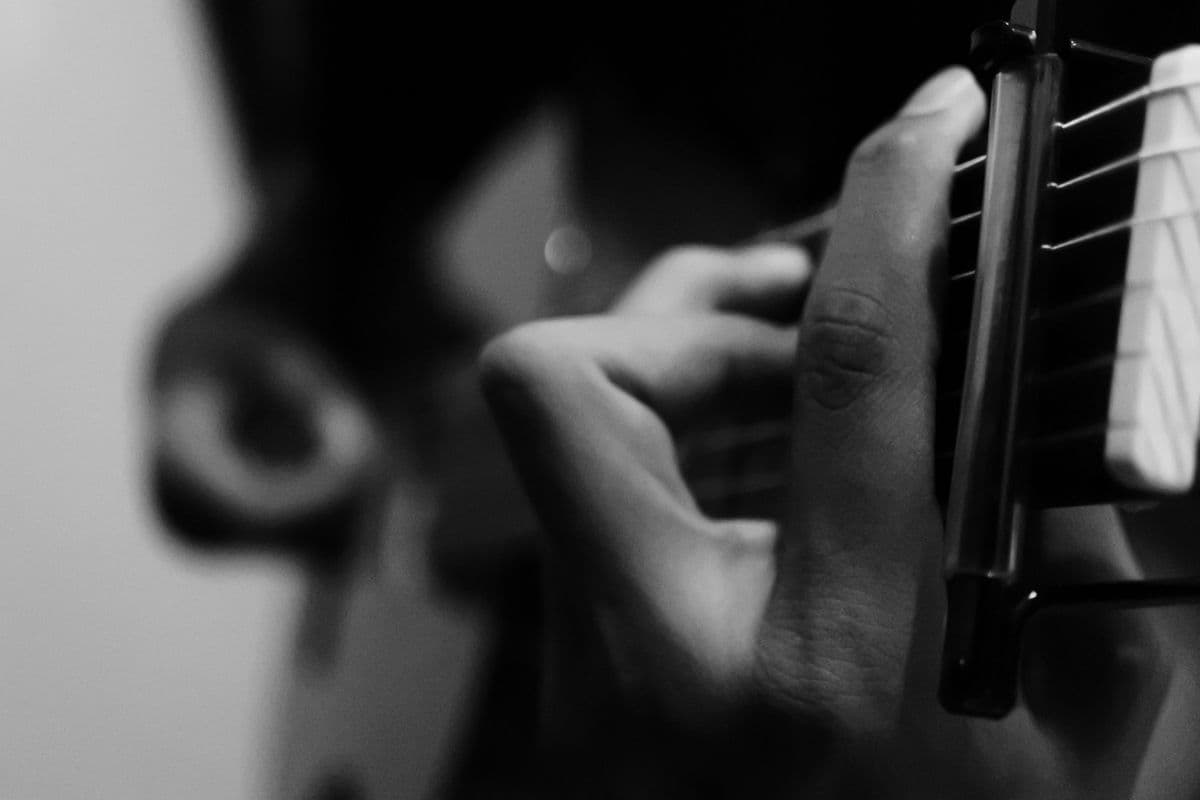 Hands playing an acoustic guitar